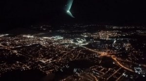 Вид из окна самолёта. Пролетая над городами ночью.