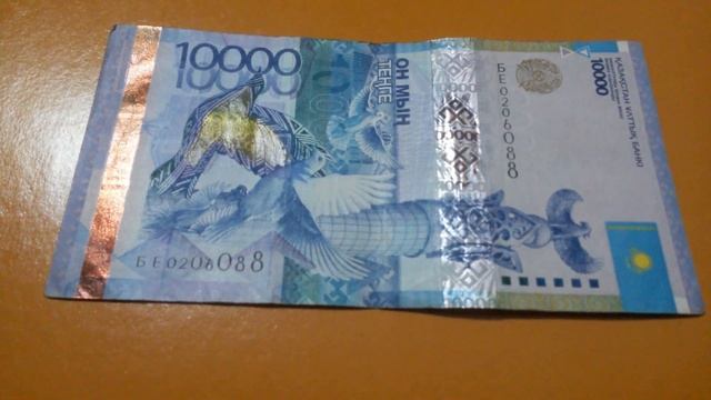 БАНКНОТА 10 000 ТЕНГЕ № серии БЕ0206088 на светло-коричневой поверхн. Второго Января ШИРОКОФОРМАТНО смотреть онлайн