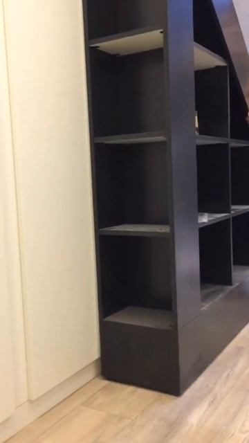 Раздвижная библиотека под лестницей