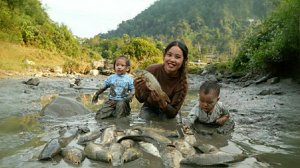 Девушка ловит гигантскую рыбу в иле, чтобы продать на рынке. Жизнь во Вьетнаме