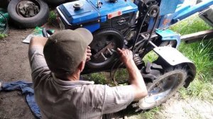 Мужик снимает маховик на мотоблоке Зубр Q78Е
