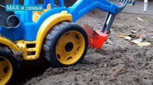 Синий трактор капает песок