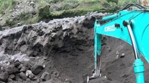 Строительство, экскаватор копает чёрный песок