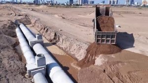 Строительство, засыпка песком , работает погрузчик