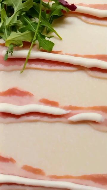 Рулетики из манго с рукколой в сырокопченом беконе.