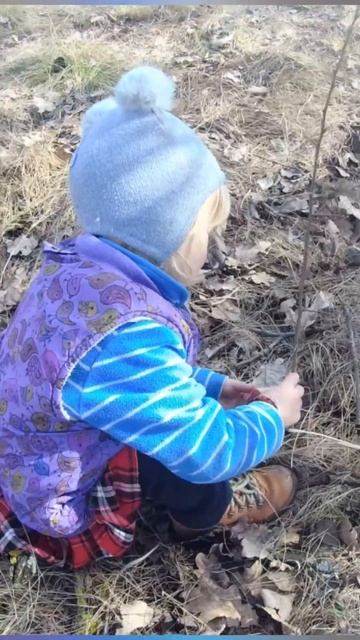 малышка делает прищепу на дерево :)