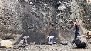 Строительство, шахтёры сбивают камни и песок со стен карьера