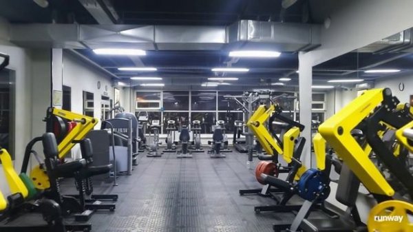 A dynamic and energetic installation of a fitness room, in the style of director Guy Ritchie, with d