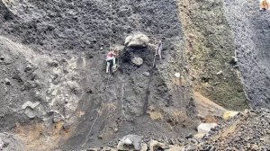 Строительство, шахтёры откапывают большие камни в карьере