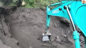 Строительство, экскаватор копает чёрный песок