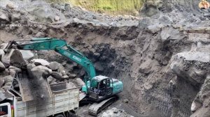 Строительство, экскаватор "копается" в огромных камнях