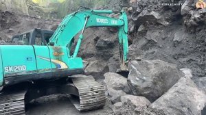 Строительство. экскаватор в карьере, сдвигает большие камни