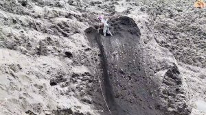 Строительство, шахтёр на стене карьера, сбрасывает песок