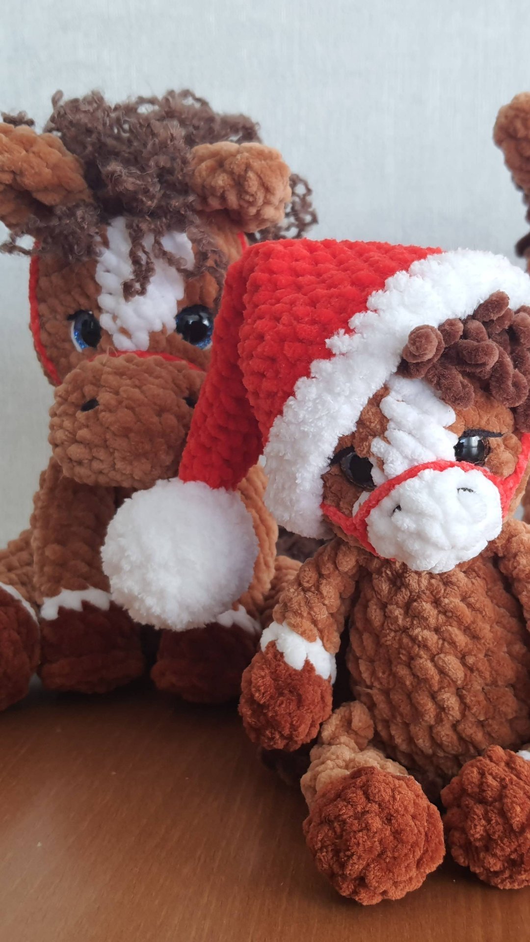 Много  вязаных плюшевых лошадок.