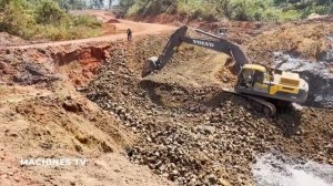 Экскаваторы и бульдозер работают над осушением и засыпкой водоема.