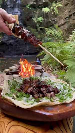 Шашлык из печени ягненка в лесу на костре