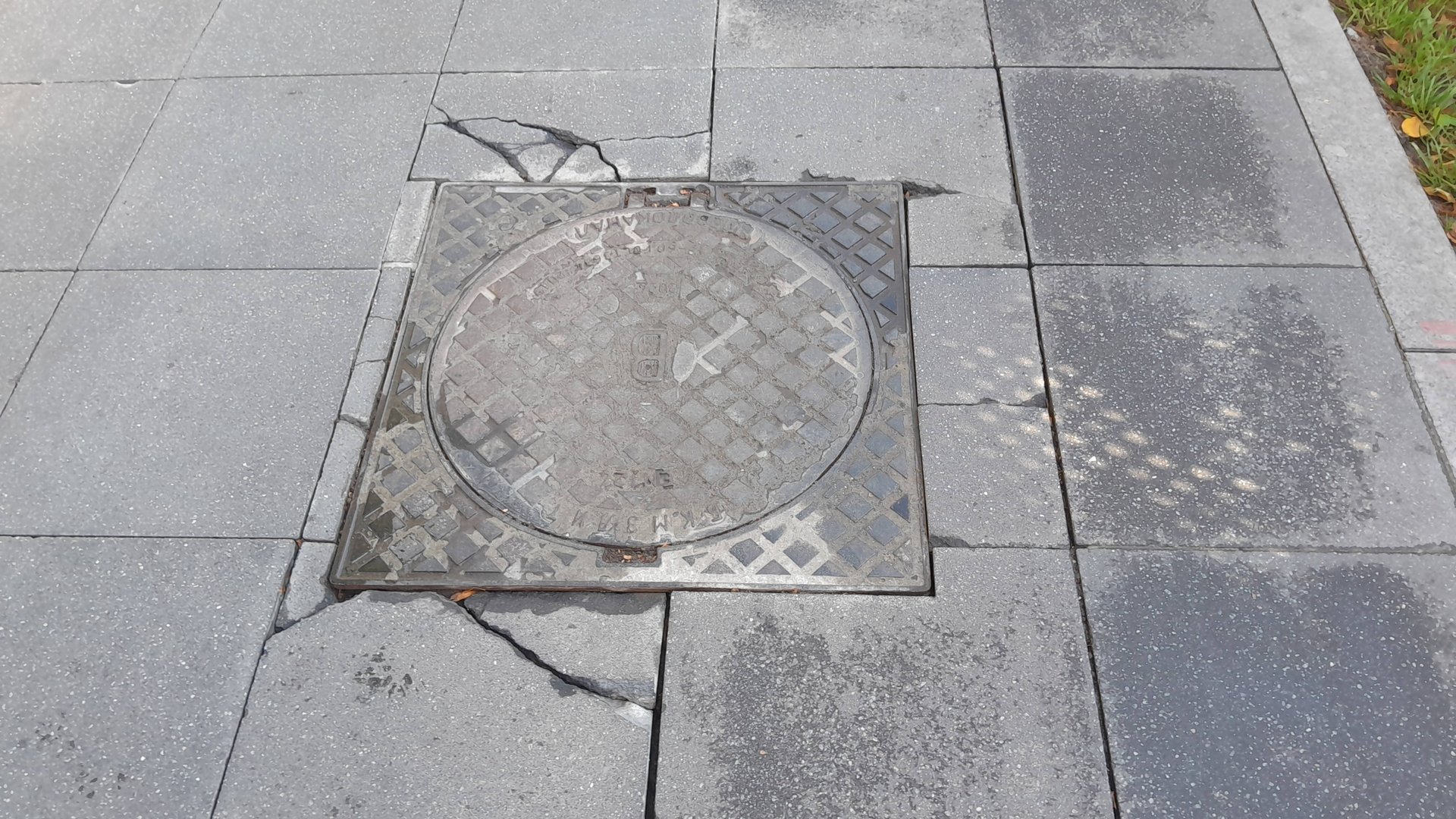 Обрамление люка при подходе мощением из плит.