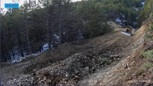 Совместная работа бульдозера и экскаватора по прокладке горной дороги.