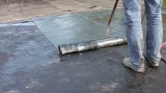 Укладка слоя Гидростеклоизола методом подплавления пламенем  горелки. Подробнее на Www.kgidrol.ru