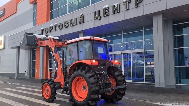 Японский трактор Kubota M704-KQ с кабиной и КУНом едет по парковке ТЦ Dexter 1 смотреть онлайн