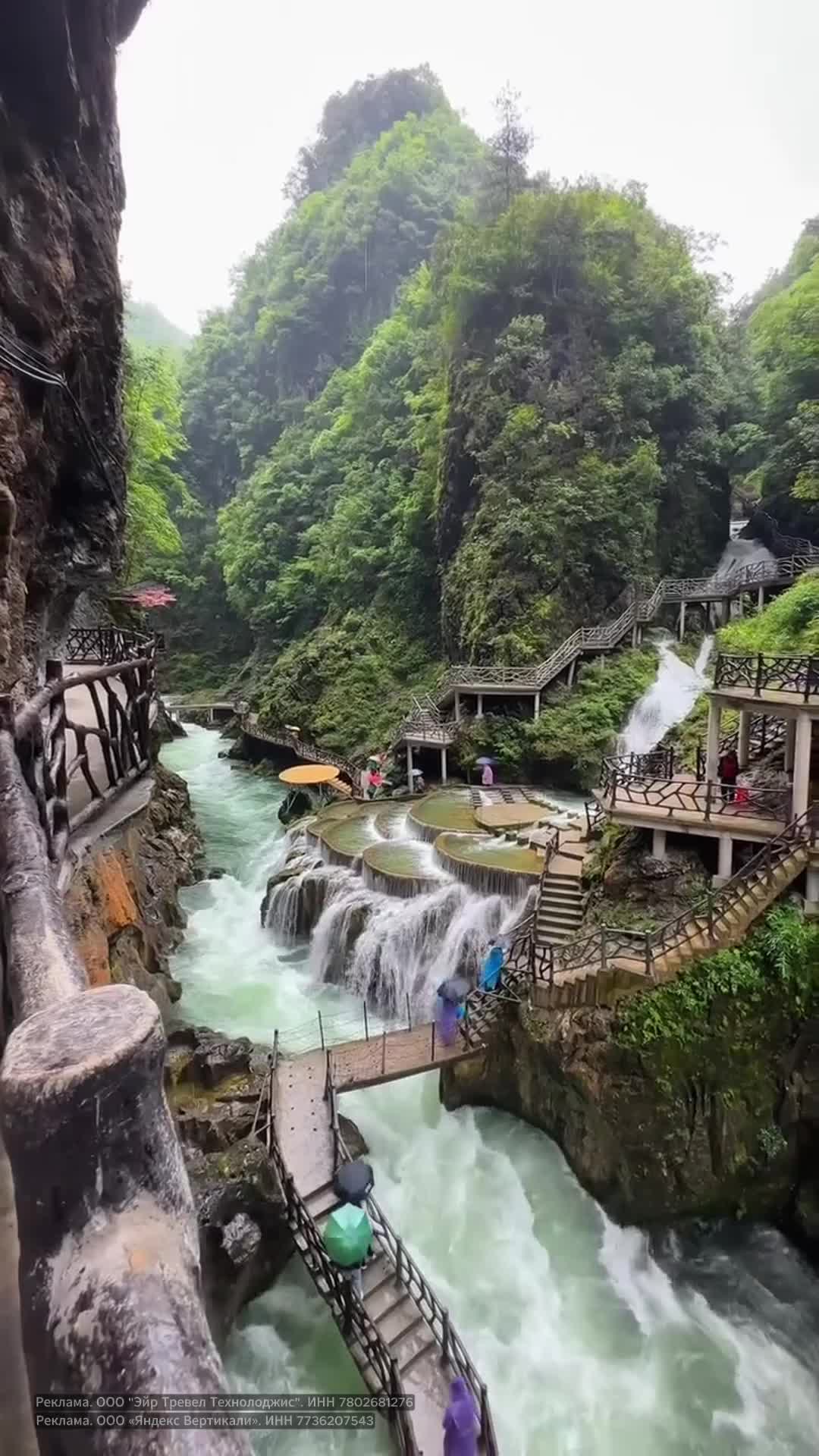 Великолепный водопад с каскадами, спускающийся среди изумрудных скал, сопровождается деревянными ... смотреть онлайн