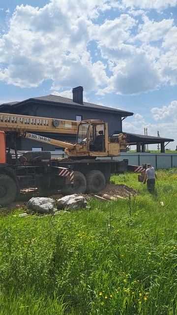 установка камней в саду при помощи крана