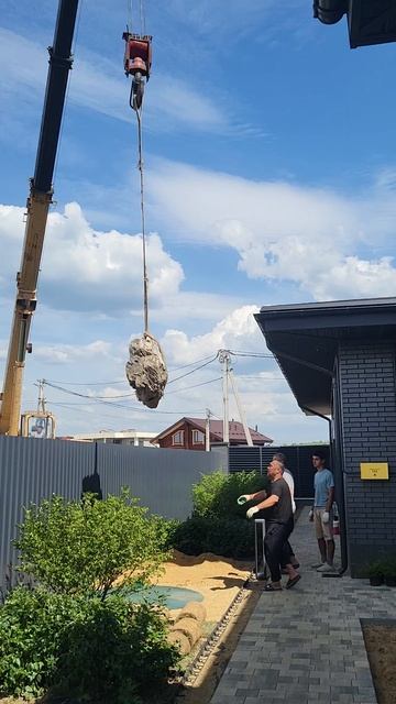 Установка камней в саду с помощью крана