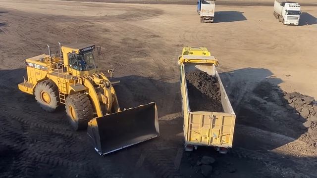 Погрузчик Caterpillar 990 загружает уголь в грузовики. смотреть онлайн