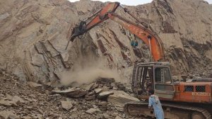 Экскаватор Hitachi EX200 пробивается через скалу.