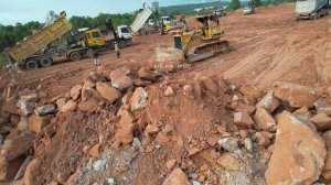 Трансформации земель: тяжелая техника, бульдозер толкает камни, самосвал разгружает.