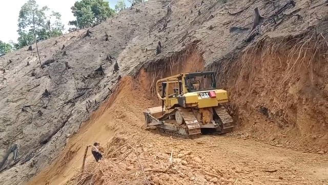 Бульдозер CAT D6R XL прокладывает дорогу на краю пропасти. смотреть онлайн