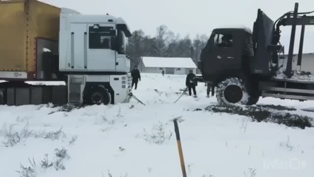 Камаз вытаскивает гружёную фуру из снега