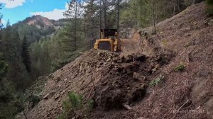 Легендарный бульдозер Caterpillar D7G передвигается в горах.