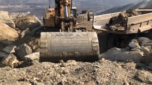 Caterpillar 375 LME экскаватор грузит камни.