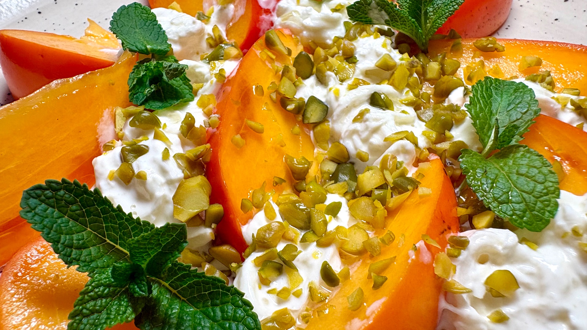 Салат из спелой хурмы,  со страчателлой  и дробленой фисташкой.