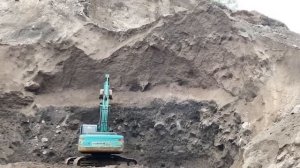 Добыча песка экскаватором в горах. Индонезия.