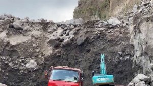 Добыча песка экскаватором в горах, опасное место работы. Индонезия.