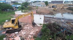 Экскаватор и бульдозер Komatsu засыпают затопленный участок города.