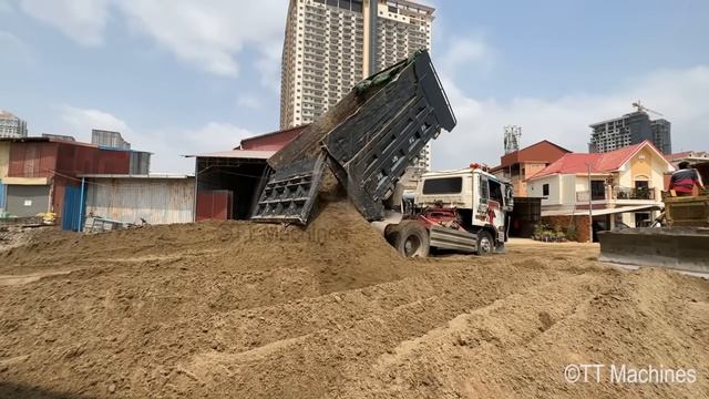 Бульдозер засыпает канаву вдоль дороги песком. смотреть онлайн