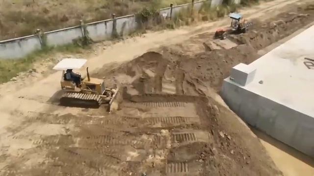 Бульдозер засыпает огромную дренажную канаву. смотреть онлайн