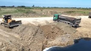 25,5-тонный самосвал провалился задними колёсами  — требуется помощь бульдозера и другого самосвала.