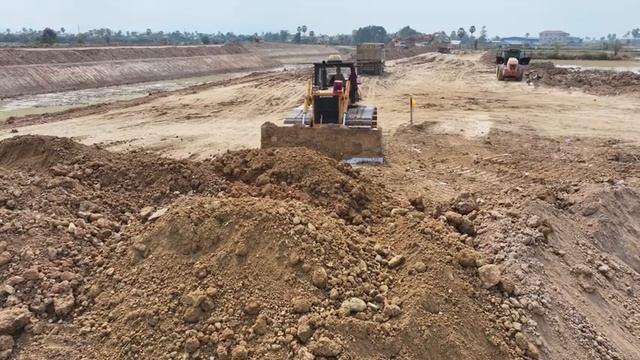 Экскаватор идёт на большой риск при строительстве канала — поддержка бульдозера и самосвала. смотреть онлайн