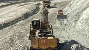 Экскаватор Komatsu PC2000 загружает карьерные грузовики.