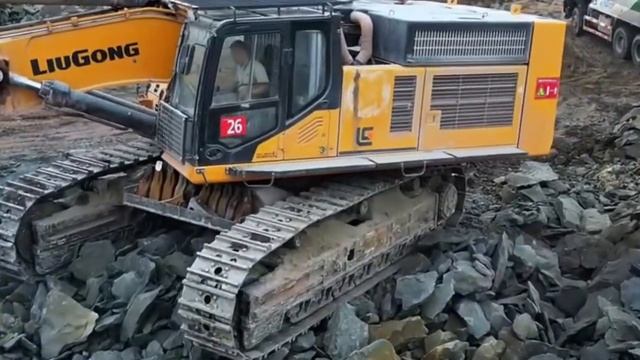 Мощные экскаваторы рыхлят каменистый грунт и загружают в грузовики. смотреть онлайн