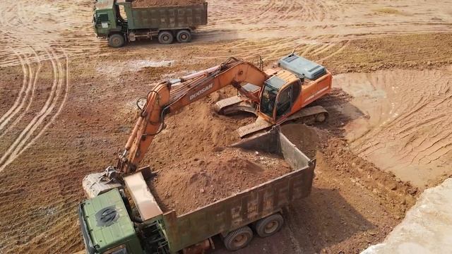 Экскаватор загружает грузовики DOOSAN, Mercedes и MAN. смотреть онлайн