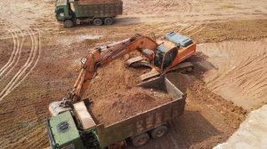 Экскаватор загружает грузовики DOOSAN, Mercedes и MAN.