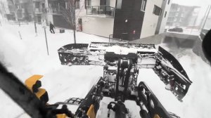 Уборка снега  трактором с крутой лопатой , вид из кабины.