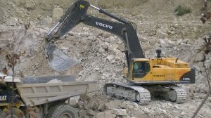 Экскаватор Volvo EC700B LC грузит самосвалы в карьере