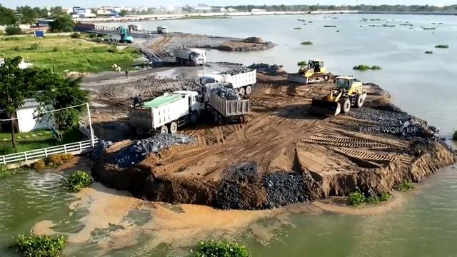 Оползень при отсыпке берега. Бульдозер толкает камни и песок. смотреть онлайн