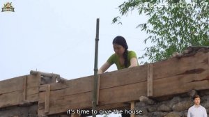 Девушка строит дом из камня и глины.